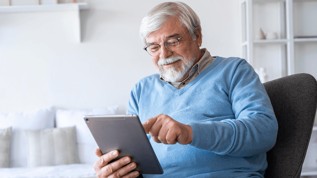 An elderly man using the Memory Machine tablet app